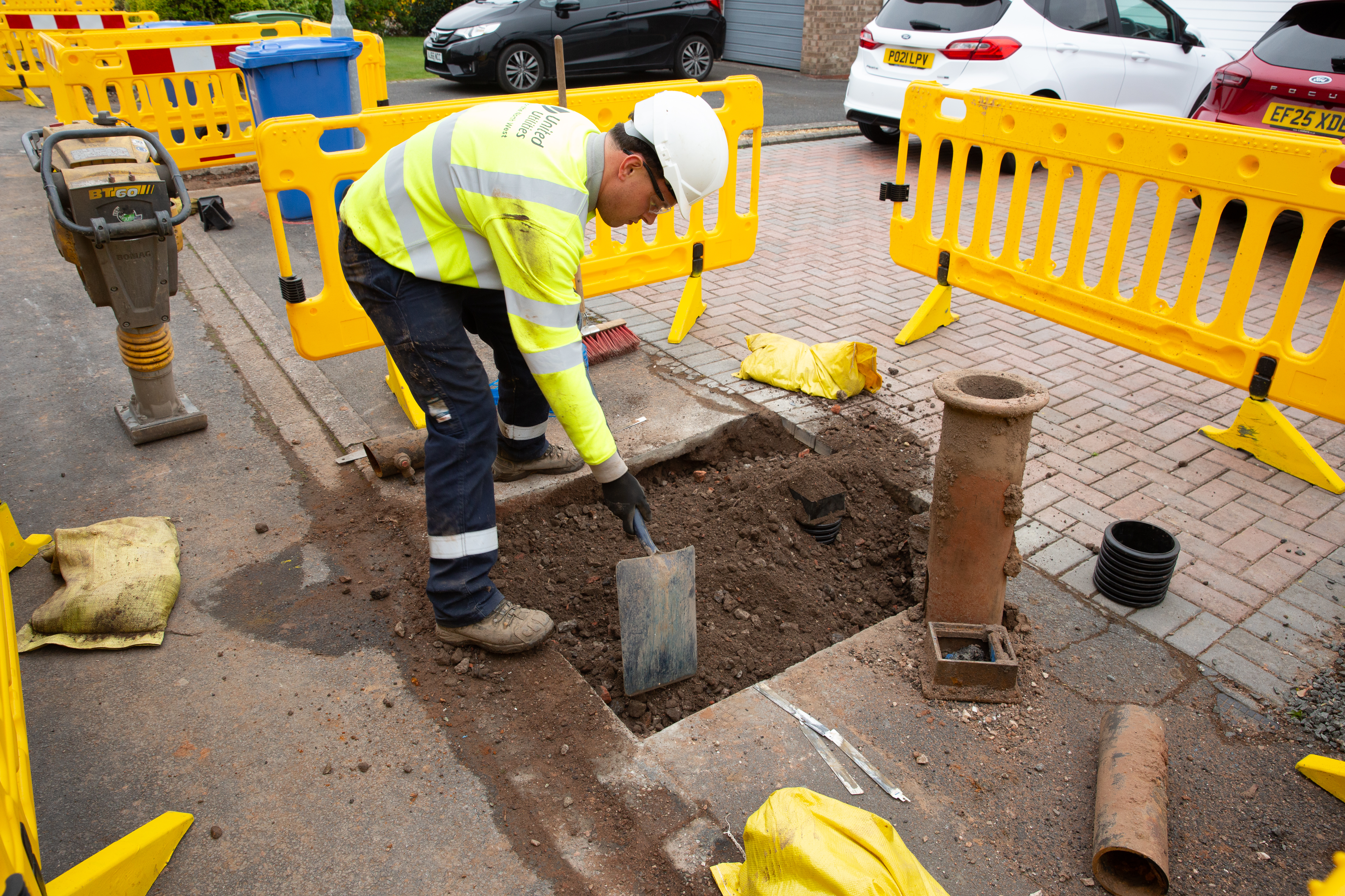 Man digging up pavement with a shovel