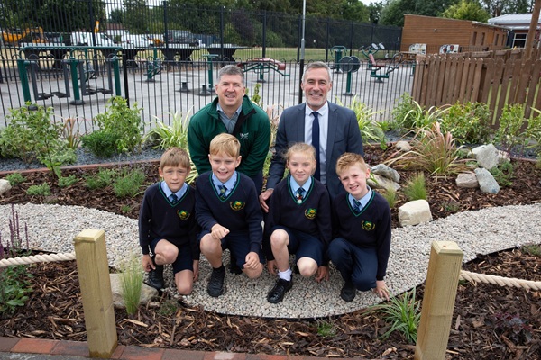 School children and teachers posing on sustainable drainage