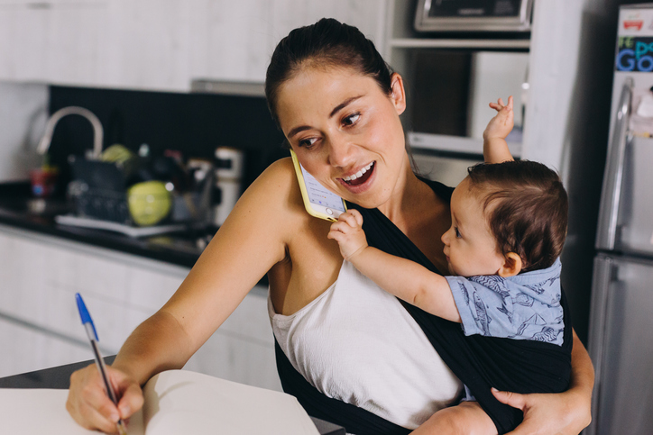 Woman on a phone call holding baby