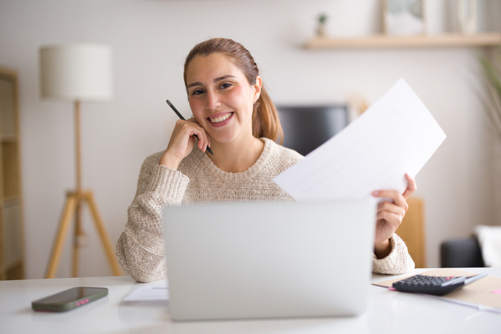 Happy woman looking at bills