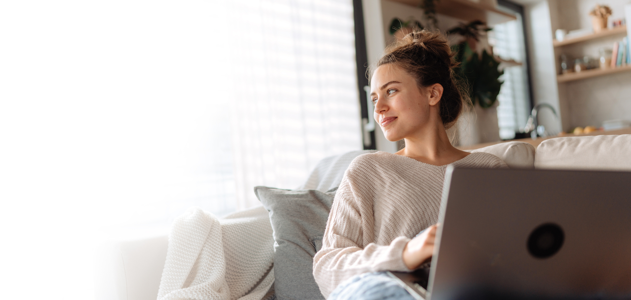 Woman sitting on couch with laptop